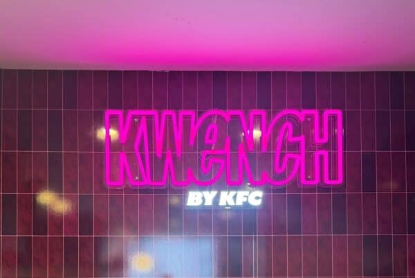 Close-up of pink illuminated KWENCH by KFC lettering on a tiled wall, part of Artline Signs’ national signage rollout.