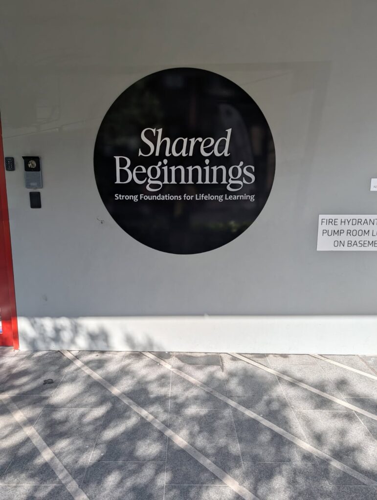 Shared Beginnings circular wall branding sign at centre entry